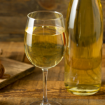 Bottle of mead with two glasses and jar of honey.